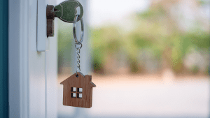 An image of a house key in a front door key hole